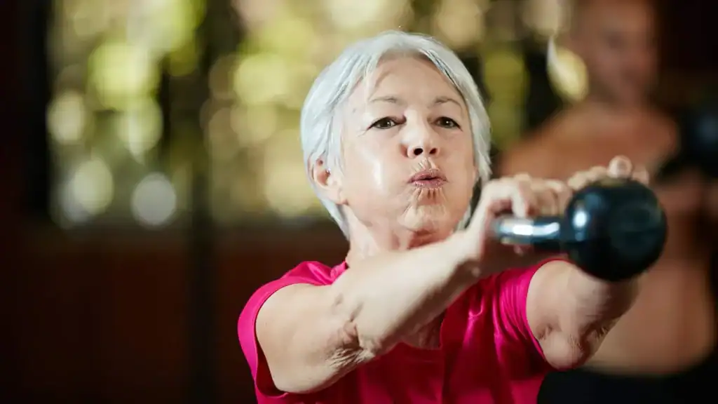 Older woman doing weight training Royal Leamington Spa to help her strength and longevity 