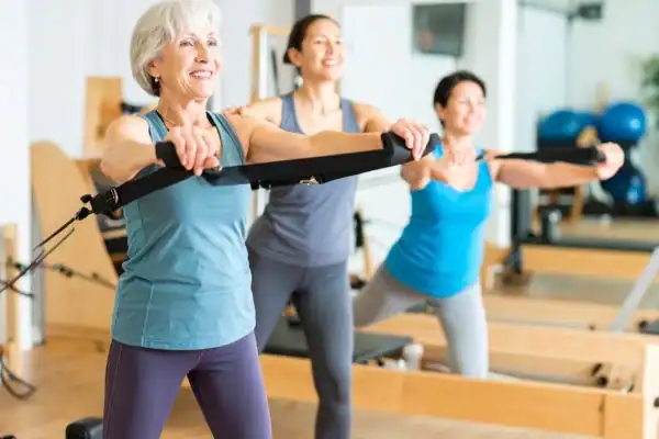 older woman doing weight training Royal Leamington Spa and resistance in the gym to tone upper arms
