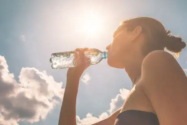 Image of woman drinking water to hydrate Royal Leamington Spa after run.